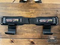 Front view of pair showing Secure Your Grip patches, metal buckle, steel hooks