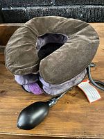 Side view of brown velvet inflatable cervical traction collar showing hand bulb pump attached