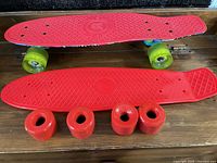 Two plastic cruiser boards, one complete, one deck only, plus four red wheels