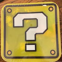 Front of sealed yellow question block box with large white “?” symbol