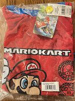 Front of packaged Mario Kart pajama set showing shirt graphic, tag and branding