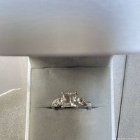 Ring front view in box showing princess cut stone and pavé shank