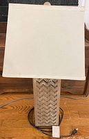 Front view of lamp showing wood base with chevron pattern and shade