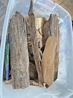 Top view of bin showing multiple driftwood pieces of various sizes and colors