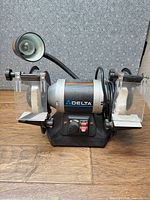 Full view of Delta GR275 bench grinder showing both wheels, shields, tool rests, base controls