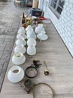 All items on table showing quantity and variety of lamp globes, platter plates and hardware