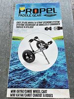 Front of retail box showing Propel Paddle Gear mini kayak/canoe wheel cart image and product details