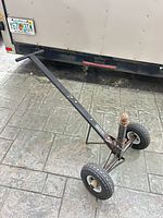 Full view of trailer dolly showing handle, frame, wheels, hitch ball