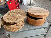 Both hat boxes closed, side by side on table