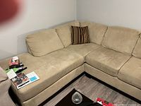 Left side view showing chaise portion, upholstery texture and one striped pillow