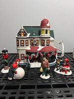 Victorian storefront with five figurines and lamppost