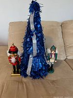 Overall lot: blue tinsel tree flanked by two nutcrackers