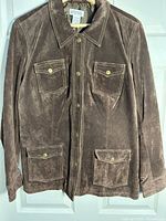 Front view of brown suede jacket showing pockets and snap closure
