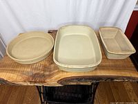 Top view of three stoneware bakers on wood table