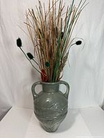 Front view of sage green vase with dried arrangement