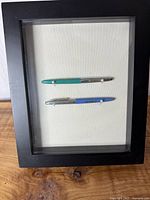 Shadow box with both pens visible