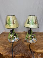Front view of two woodland night lamps on table