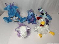 Group shot of five assorted plush toys on white background