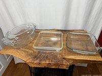 All three clear glass baking dishes displayed side by side on wooden surface