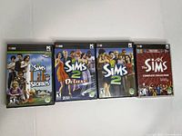 Front view of four PC game cases: Sims Life Stories, Sims 2 Deluxe, Sims 2, Sims Complete Collection