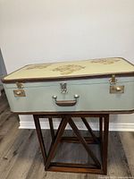 Suitcase on wooden base front view showing hardware