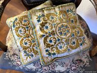 Two matching square pillows showing full front design