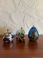 Front view of three hand blown glass oil lamps