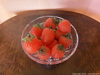 Bowl of nine red glass strawberries, side view