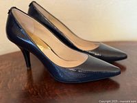 Side profile of both pumps showing toe shape and heel height