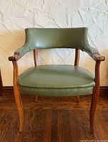 Front view of green vinyl mid-century arm chair showing seat, arms, legs