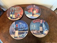 All four wine-themed salad plates displayed on table