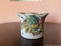 Profile view showing bird, leaves and flowers on crackle glaze body