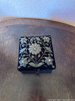 Top view of black velvet jewelry box with embroidered floral and bead design