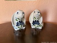 Front view of both ceramic rabbits showing floral design