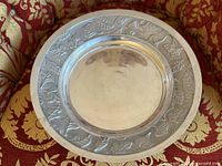 Full view of round metal tray on patterned fabric