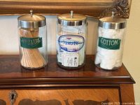 Front view of three labeled glass jars on wooden surface