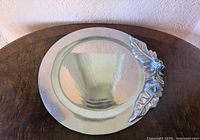 Full view of round metal tray showing floral relief on edge