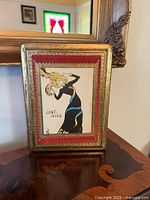 Full view of framed Jane Avril print on tabletop