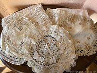 Group of assorted lace and embroidered doilies on table
