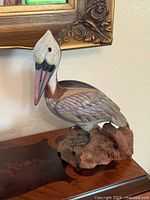 Front view of carved wooden pelican on driftwood base