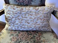 Front view of rectangular embroidered pillow on chair