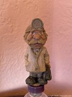 Front view of Doctor Ben Dover figurine atop cork