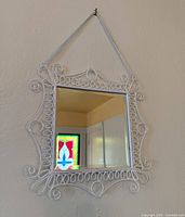 Front view of square white metal scrollwork mirror with hanging chain