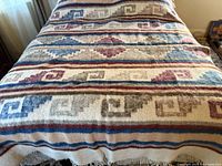 Blanket laid on bed showing full pattern and colors