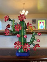 Front view of cactus carving displaying flowers and hummingbirds