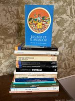 Front view showing upright copy of Poesía de El Salvador and full stack of additional books