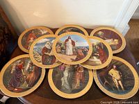 Eight Danbury Mint Ten Commandments plates arranged on table