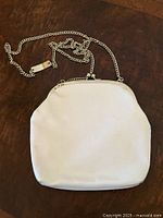 Front view of white coin purse with chain strap