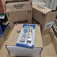Blister-packed Weiser latch resting on cartons
