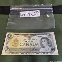 Front of 1973 Canada $1 bill with serial BC56386872 in plastic sleeve